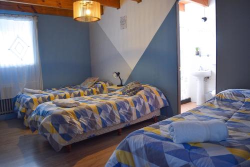 three beds in a room with blue walls at Berkana hostel Bariloche in San Carlos de Bariloche