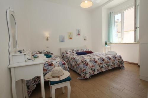 a bedroom with two beds and a table and a mirror at Casa Calieri in Tropea