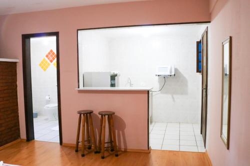 a bathroom with a sink and two stools at Pousada da Brigida in Campos do Jordão