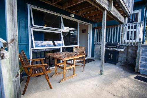 a wooden table and two chairs on a patio at Coromandel Seaview Motel in Coromandel Town