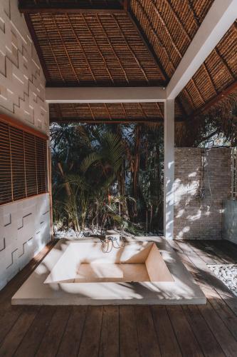 an outdoor bathtub in the middle of a patio at La Cabane in Jimbaran