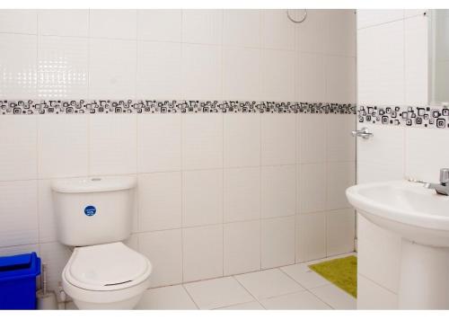 ein weißes Badezimmer mit Toilette und Waschbecken in der Unterkunft III NICE 2 BEDROOM APARTMENT Bocagrande in Cartagena de Indias