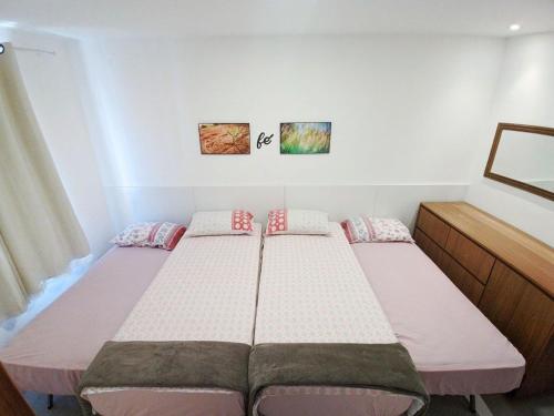 a bedroom with two beds in a room at Guarajuba Porto Smeralda Village C02, térreo - GUARAJUBA TEMPORADA, viva mais de uma experiência de hospedagem conosco! 130m da praia in Guarajuba