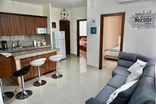 a living room with a blue couch and a kitchen at Garzota Suites Airport in Guayaquil