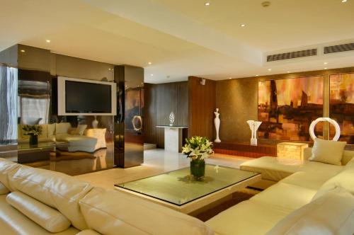 a living room with a white couch and a tv at Marco Polo Parkside, Beijing in Beijing