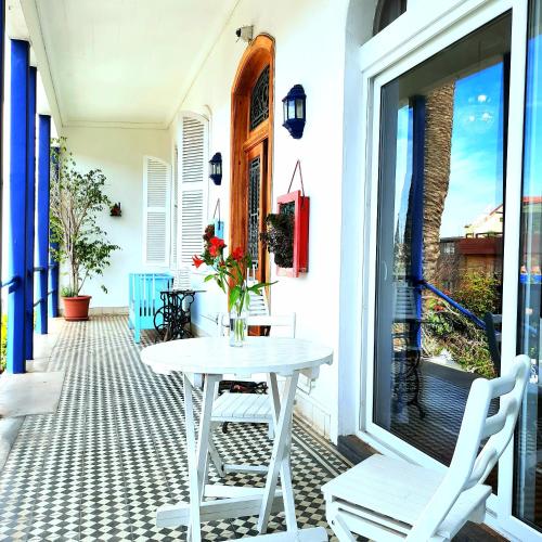 a white table and chairs on a porch at Hotel Casa Somerscales in Valparaíso