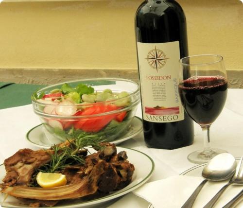 a bottle of wine and a plate of food and a glass of wine at Room in Susak with air conditioning, W-LAN (3865-4) in Susak