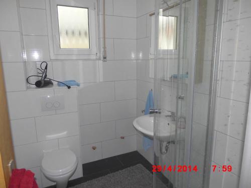 bagno bianco con servizi igienici e lavandino di Frankfurt Airport & Fair Apartment a Kelsterbach