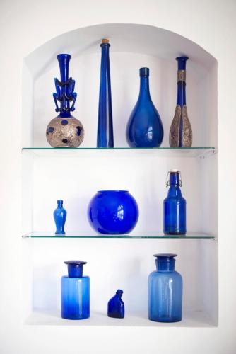 a bunch of blue vases sitting on shelves at Hotel Casa Somerscales in Valparaíso