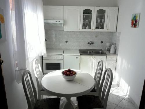 kuchnia ze stołem, na którym stoi miska z owocami w obiekcie Apartment in Sukošan with sea view, terrace, Wi-Fi (4813-2) w Sukošanie