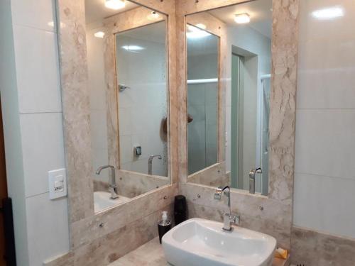 een badkamer met een wastafel en een spiegel bij Apartamento Diamante in Águas de Lindóia