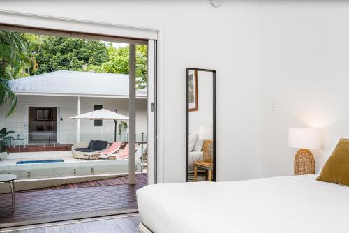 a bedroom with a bed and a patio with a pool at Cove Studios in Byron Bay