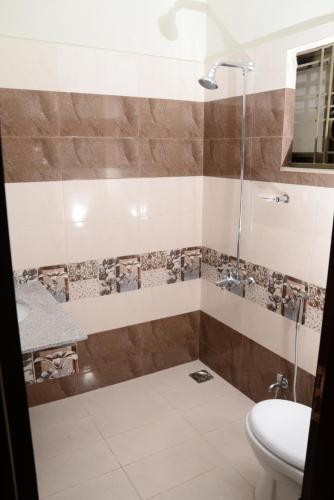 Un baño con ducha, inodoro y lavabo. en Cuzzy Inn Hotel, en Lahore