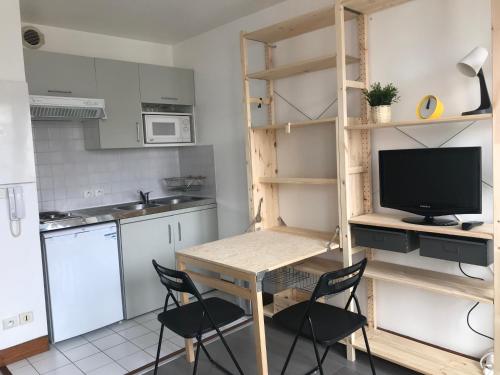 une cuisine avec une table et des chaises et une télévision dans l'établissement Votre pied a terre sur le port de La Rochelle, à La Rochelle