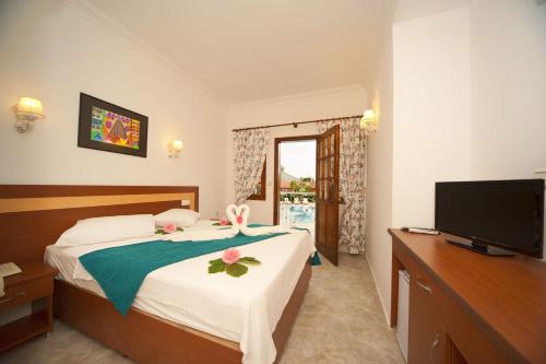 a hotel room with a bed and a television at White Hotel in Oludeniz