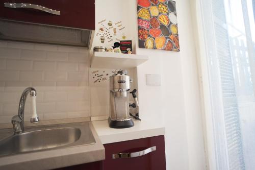 uma cozinha com um lavatório e uma mesa de mistura num balcão em Appartamento Piazza Anco Marzio em Lido di Ostia