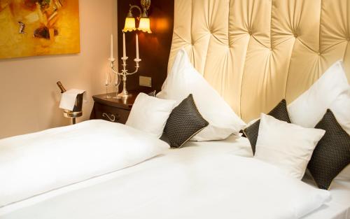 a bedroom with a large bed with white pillows at Residence Bellevue in Boppard