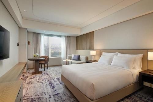 a hotel room with a large bed and a living room at Lotte Hotel World in Seoul