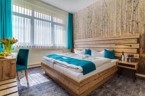 a bedroom with a bed and a desk and a chair at Panorama Ferien Hotel Harz in Güntersberge