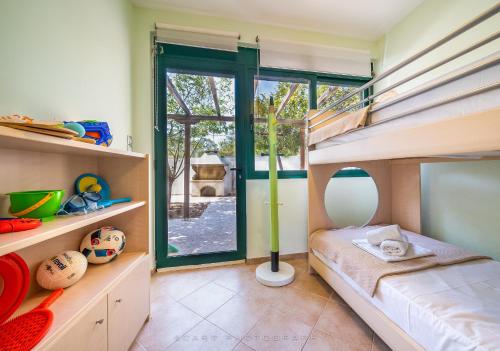 Camera per bambini con letto a castello e scala di FLUO Seaside Apartment a Vathí