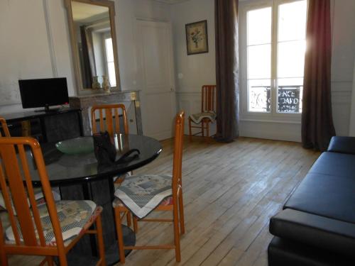 a living room with a table and chairs and a couch at Le Sarciron in Le Mont-Dore