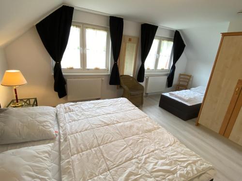 a bedroom with two beds and two windows at Moderne Apartments im Ferienpark auf Rügen in Sagard