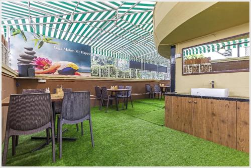 a restaurant with a table and chairs and green carpet at Hotel Green Field in Satara
