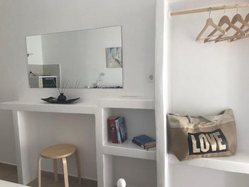 a room with a desk with a mirror and a stool at Morpheus Rooms in Kinion