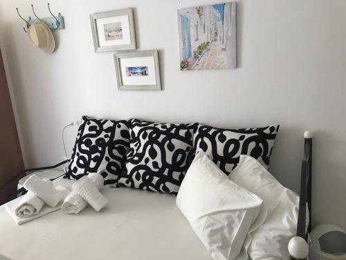 a bed with black and white pillows on it at Morpheus Rooms in Kinion
