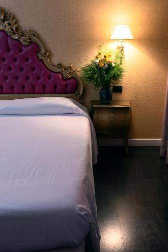 a hotel room with a bed and a table with a lamp at Hotel - Motel Flower in Gropello Cairoli