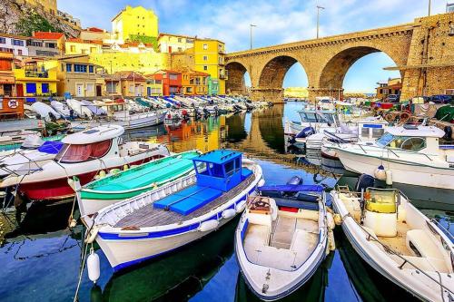 um grupo de barcos ancorados num porto com uma ponte em Une calanque au coeur de la ville em Marselha