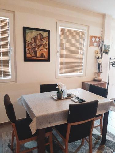 a dining room table with chairs and a painting on the wall at DS center apartment in Ohrid