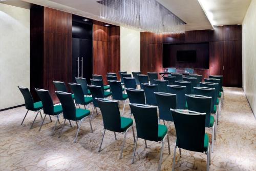 a conference room with chairs and a projection screen at Southern Sun Abu Dhabi in Abu Dhabi
