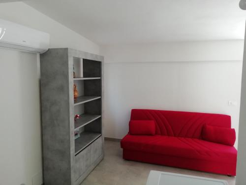 a red couch in a room with a book shelf at La locanda di Gioele in Lido di Camaiore