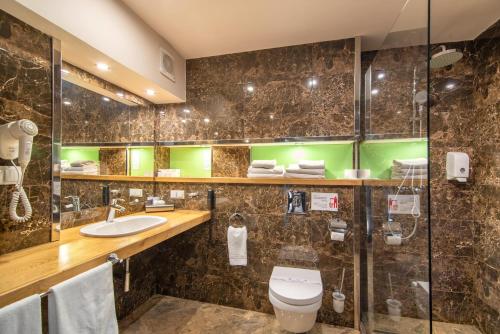 a bathroom with a toilet and a sink at F&B Spa Resort (ex. Fomich Hotel) in Bukovel