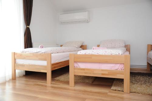 two twin beds in a room with wooden floors at Kuća za odmor Gloria in Travnik
