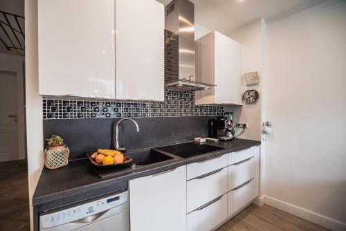 a kitchen with white cabinets and a bowl of fruit on the counter at Apartment Dajana in Bovec