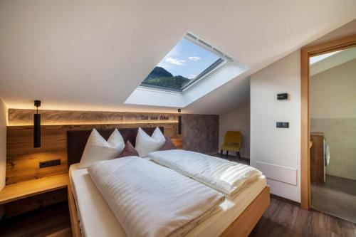 une chambre avec un grand lit avec une lucarne dans l'établissement Ferienwohnung Barrique, à Merano
