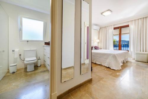 a white bedroom with a bed and a toilet at Marbat Plus in Port de Soller