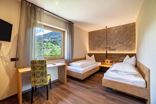 pokój hotelowy z 2 łóżkami i oknem w obiekcie Ferienwohnung Pinot w Meranie