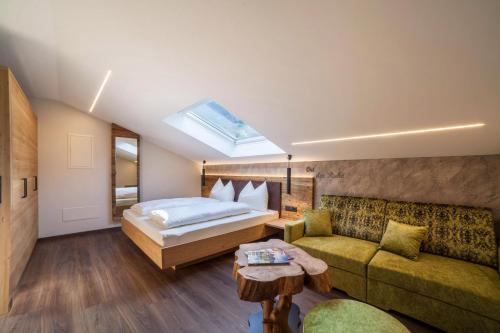 um quarto com uma cama e um sofá em Ferienwohnung Cuve em Merano