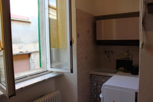 a small bathroom with a window and a sink at La casa di Rina in Ponzone