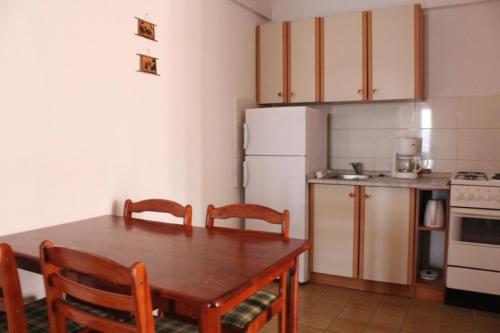 La cuisine est équipée d'une table, de chaises et d'un réfrigérateur blanc. dans l'établissement Apartment in Pisak with sea view, terrace, air conditioning, WiFi (3817-3), à Pisak