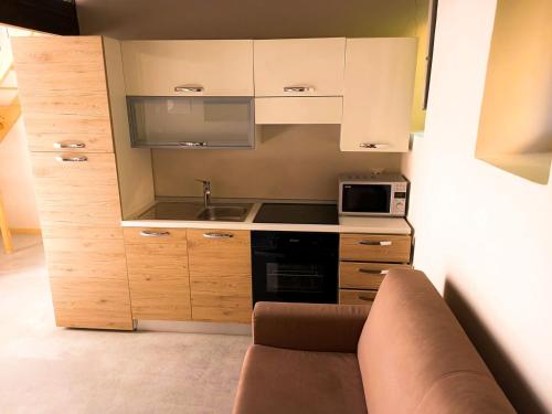 a small kitchen with a couch and a microwave at Relais Real Collegio in Noli