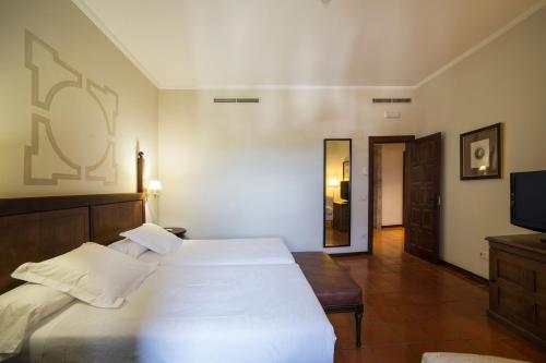 a bedroom with two beds and a flat screen tv at Parador de Monforte de Lemos in Monforte de Lemos