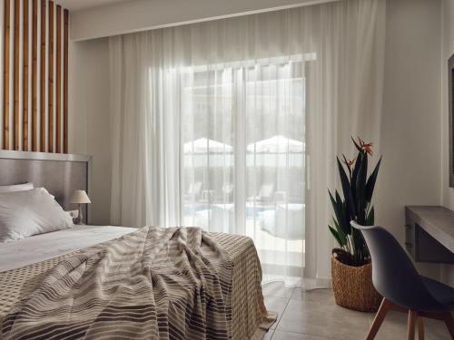 プラノスにあるDareia Suitesのベッドルーム1室(ベッド1台、窓、椅子付)