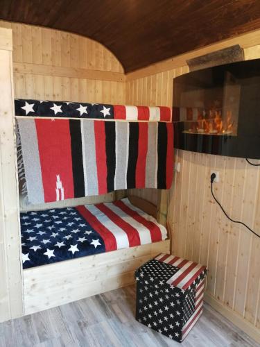 a wooden cabin with an american flag themed bed at Schäferwagen Grünspecht in Ratingen
