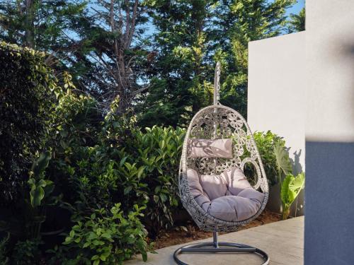 a wicker chair sitting on a patio next to a bush at Dareia Suites in Plános
