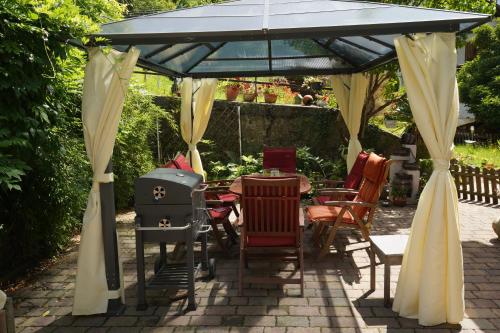 a gazebo with a table and chairs under it at Ferienwohnung Sabine in Schmalkalden