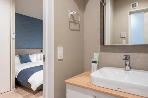 a bathroom with a sink and a bed at hotel aima in Tokyo